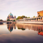 Kolonnaden der Museumsinsel mit Blick auf den Berliner Dom und Spiegelung in der Spree.