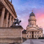 Gendarmenmarkt with French Cathedral and Concert Hall at sunset.