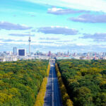 Panorama over the Tiergarten along Straße des 17. Juni to the Brandenburg Gate, with the Berlin TV Tower behind it.