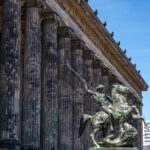 Colonnaded façade of the Altes Museum on Museum Island with the Lion Fighter statue in the foreground.