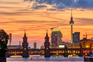 Berlins Skyline mit Oberbaumbrücke und Fernsehturm bei Sonnenuntergang über der Spree.