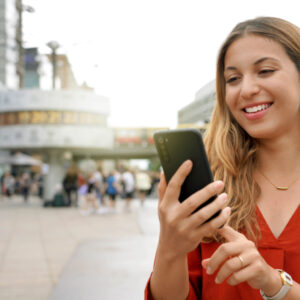 Close up of young woman using mobile phone in Berlin city square Alexanderplatz